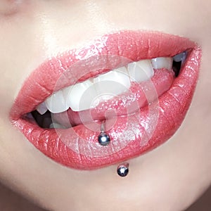 Girl`s lips make-up lipstick lip gloss cosmetic swatch teeth tongue piercing fashion macro photo