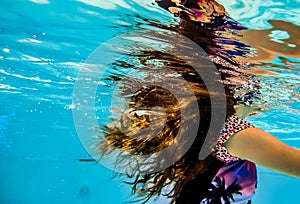 A girl`s long hair flowing underwater and reflections on the undersurface of the water
