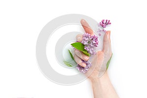 Girl`s palm of a girl in a bath with milk and flowers. Copy space, flat lay. The concept of purity, tenderness, freshness, youth.