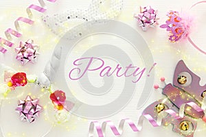 girl& x27;s party concept. unicorn head decoration, pink wand, mask and toy over white wooden background.