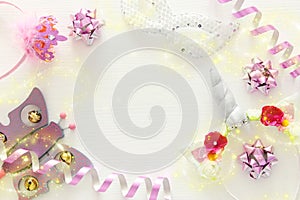 girl& x27;s party concept. unicorn head decoration, pink wand, mask and toy over white wooden background.