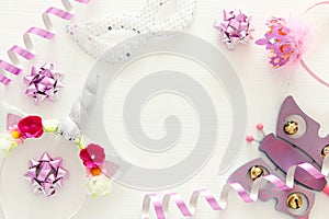 girl& x27;s party concept. unicorn head decoration, pink wand, mask and toy over white wooden background.