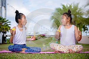 Girl`s play and Enjoy activities Blow bubbles in the park , Friend