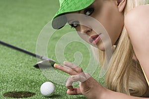 Girl's playing with golf ball looks in to the lens