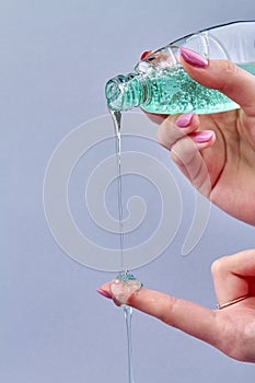 Girl`s pouring green liquid soap.