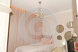 Girl's room with pink details, round mirrors on the wall, beautiful chandelier and desktop computer