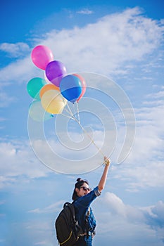 Girl`s travel and holds a ball of light color on a bright day sk