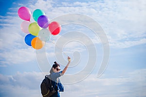 Girl`s travel and holds a ball of light color on a bright day sk