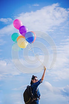 Girl`s travel and holds a ball of light color on a bright day sk