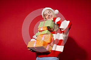 A girl in sa red santa hat with christmas presents