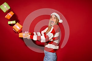 A girl in sa red santa hat with christmas presents