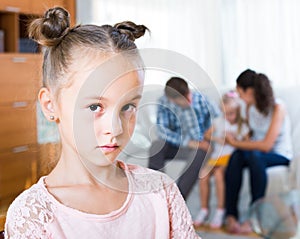 Girl sad because of jealous younger sister to parents