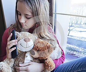 Girl sad window , bear with phone