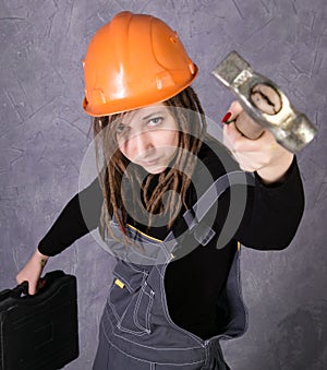 Girl in safety helmet orange vest holding hammer tool