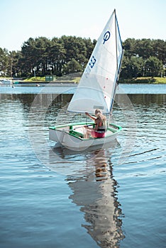 The girl in sailboat on the lake.