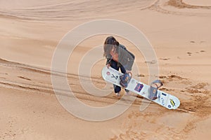 Girl sand boarding in desert