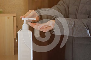 Girl sanitazing her hands in the hall after returning from street