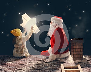 Girl and Santa Claus sitting on the roof