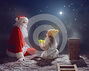 Girl and Santa Claus sitting on the roof