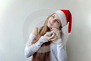 Girl in Santa hat with christmas balls in the hands