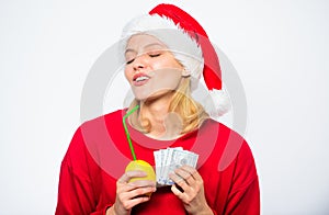Girl santa hat drink juice lemon while hold pile money. Make money on fresh lemonade. Christmas profit concept. Lemon