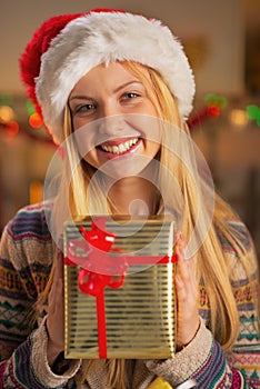 Girl in santa hat holding christmas present box