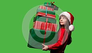 A girl in a Santa hat holds a lot of gifts for Christmas and New Year 2023. Happy childhood. Sale and Black Friday