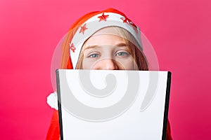 Girl in Santa hat and tinsel on the neck, a teenager holding a t