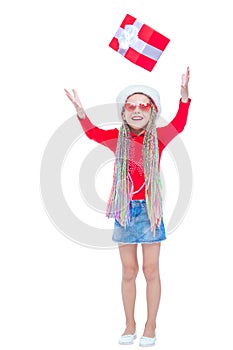 Girl in Santa`s hat. Portrait of little cute girl holding box of Christmas present, Small girl hug her gift with happy