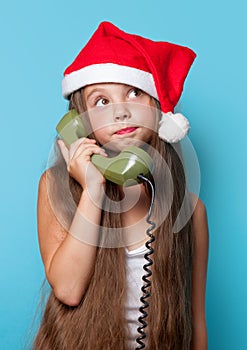 Girl in Santas hat calling by phone