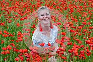 Girl sat in the middle of a poppy field