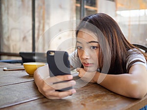 The girl sat staring at the phone in hand. A sad expression awaits the boyfriend calling