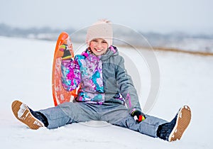 Girl with saucer sled on the snow