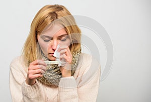 Girl in scarf hold thermometer and tissue close up. Cold and flu remedies. High temperature concept. Take temperature