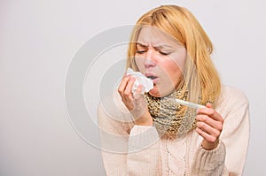 Girl in scarf hold thermometer and tissue close up. Cold and flu remedies. Take temperature and assess symptoms. Measure