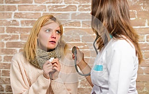 Girl in scarf hold tissue while doctor examine her. Cold and flu remedies. Recognize symptoms of cold. Remedies should