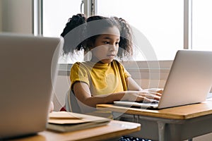 Girl in school studying using laptop