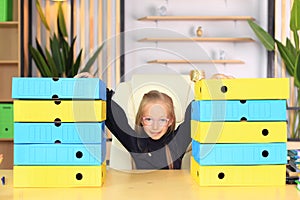 A girl in a school uniform sits at the table for lessons.