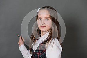 Girl in school uniform standing at the chalkboard