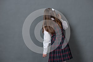 Girl in school uniform standing at the chalkboard