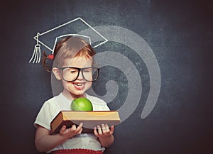 Girl schoolgirl with books and apple in a school board