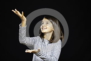 Girl, schoolgirl meditates, expresses emotions, close-up on a black background