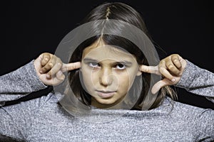 Girl, schoolgirl meditates, expresses emotions, close-up on a black background