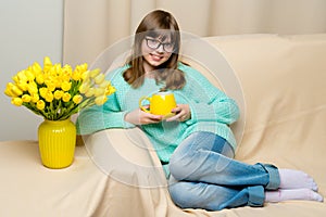 Girl schoolgirl with a mug in her hands.