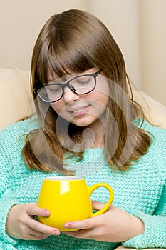 Girl schoolgirl with a mug in her hands.