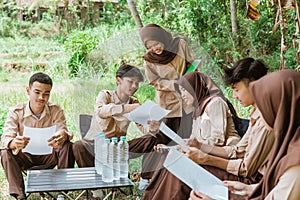 girl scout squad leader and her friends doing paper assignments