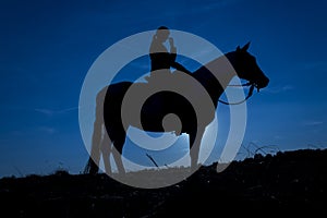 Girl scratching her nose, horse at sunset in blue