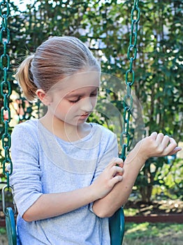 Girl Scratching itchy Eczema on Swing