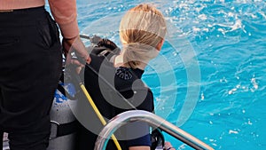 a girl with scuba diving is sitting on board a yacht, preparing to dive, diving in the sea