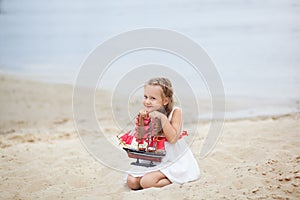 Girl on the sea with a ship. Close-up portrait of the girl`s face. little girl wait boat with scarlet sail. Girl on the beach in a